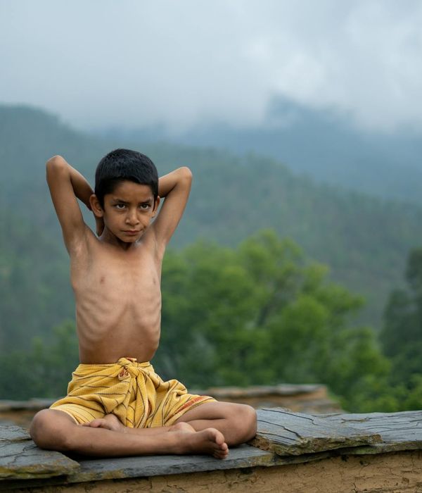Woman practicing yoga outdoors with a serene nature background.